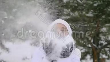 年轻快乐的女人在降雪时吹雪花，在缓慢的运动中享受冬天的时光。 1920x1080